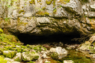 A cave opening in a mountain. Dark entrance into a mysterious world.