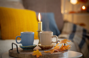 two  cups with hot drinks at home with autumnal decor