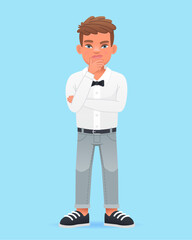 The little boy was thinking about something. A beautiful cute schoolboy child in a white shirt with a bow tie.