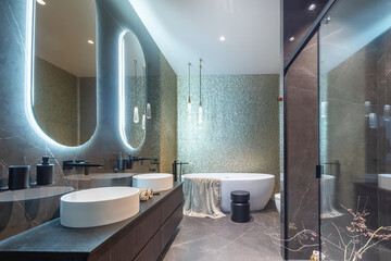 Exclusive design of the bathroom, decorated in gray tones. Oval mirrors with illumination .over the...