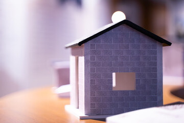 Obraz na płótnie Canvas 3D model of a solitary house under a tiled roof of a residential building. on bokeh light background