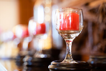Clear glass with spa candles placed on coasters in spa shop, bokeh light background