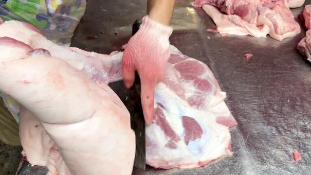 4K Cut the pork carcass with a knife. The butcher separates the fat from the carcass. Work in a meat shop on a maket