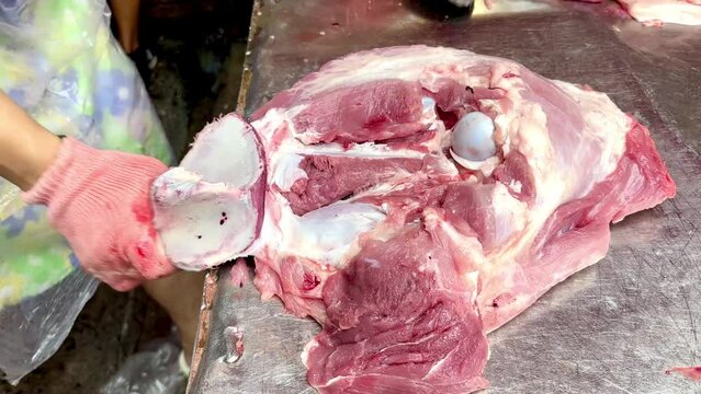 4K Cut the pork carcass with a knife. The butcher separates the fat from the carcass. Work in a meat shop on a maket