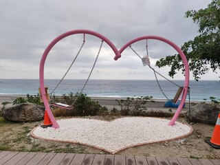 The blue seaside, the deactivated heart-shaped swing in autumn