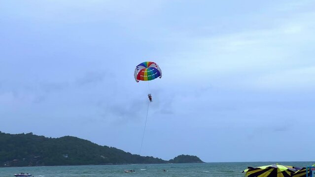 Parasailing on a windy day at Patong Beach phuket thailand. Speed boats and jet sky&rsquo;s roaming 