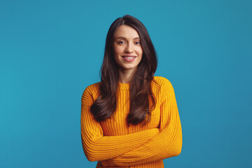 Portrait of satisfied woman model, dressed in casual orange jumper, looks straight at camera,...