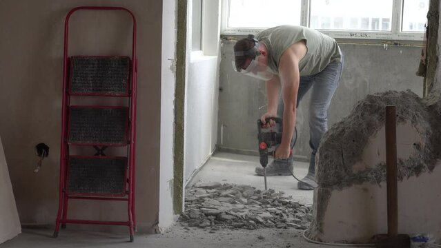 The jackhammer breaks the cement screed. Work with a perforator. A close-up of the perforator chisel. Under construction. Knocking down excess concrete in the apartment. High quality 4k footage