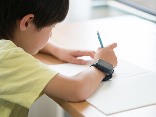 スマートウォッチを身につけて勉強している男の子