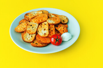 Toasted bread slices with tomato and mozzarella flavor on a yellow background