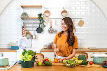 Portrait of beauty body slim healthy asian woman having fun cooking and preparing cooking vegan food healthy eat with fresh vegetable salad on counter in kitchen at home.Diet concept.Fitness, healthy