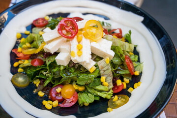 A delicious vegetarian caesar salad with white cheese, dressing, jalapeno and croutons