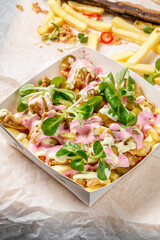 French fries with meat, sauces, green and pickles 