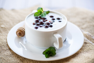 Cooked milk semolina porridge with berries and honey in a plate.