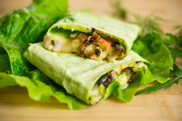 green hot vegetarian pita bread with mushrooms and different vegetables, with lettuce leaves .