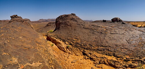 Fototapeta na wymiar West Africa. Mauritania. Panorama of lava formations of ancient volcanoes on top of a destroyed plateau in the Agro Nature Park near the town of Shingetti.