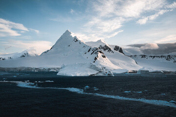 Beautiful snow-capped mountains against the sunset sky in Antarctica. Global warming and travel...