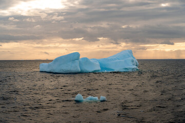 Beautiful iceberg floating in the water. Photo taken at sunset in Antarctica and Arctic Greenland. Global warming and climate change and travel concept.