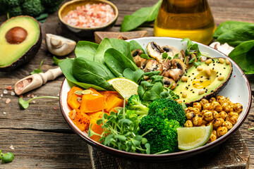 Green vegetable vegan salad with avocado, mushrooms, broccoli, spinach, chickpeas, pumpkin. Healthy vegetarian food concept. top view