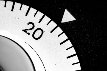 monochrome close-up of an old analog laboratory timer set to 21