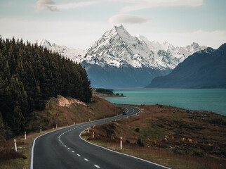 Scenic winding road along Lake Pukaki to Mount Cook National Park, South Island, New Zealand during cold and windy winter morning. One of the most beautiful viewing point of Aoraki Mount Cook.