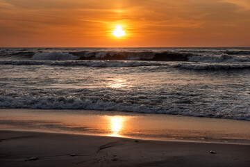 przepiękny zachód słońca nad morzem, oceanem - z falochronami, falami - obrazy, fototapety, plakaty