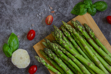 Green asparagus on a dark background, close up. Preparation for cooking.