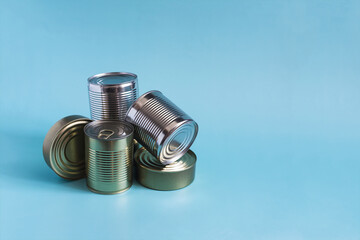 Cans with different products in close-up on a blue background. Long-term storage products.