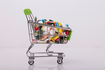 Supermarket grocery cart filled with medical pills. The concept of replacing natural products with...