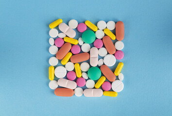 Colorful pills on blue background. Top view. Copy space. 
