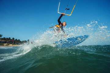 Kite surfer riding a kiteboard on the sea with splash