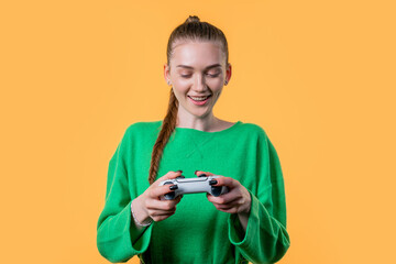 Young woman playing online video game, console TV with joystick yellow backdrop