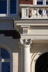 A substantial close-up shows a section of the balcony and columns of the historic building.