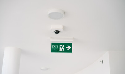  a green exit sign on a white wall
