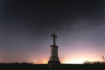 kapliczka murowana z krzyżem w polu na tle nocnego nieba z gwiazdami - obrazy, fototapety, plakaty