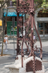 Fototapeta na wymiar Public Bench with Wrought Iron Ornament in Passeig de Gracia Street in Barcelona, Spain