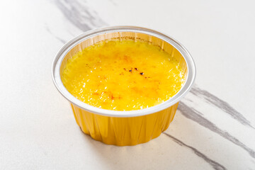 angle view caramel pudding on a white table