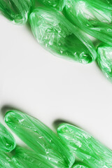 Minimal pattern from green disposable plastic bags on white Waste reduction, Environmentally friendly, recycling concept. Pollution from Polyethylene packets, plastic bag free day