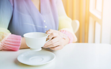 Woman's hand holding a cup of coffee, feeling relaxed