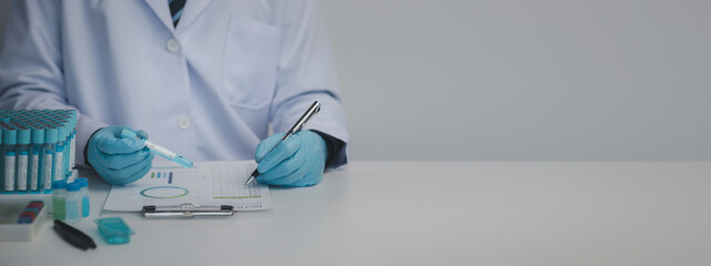 Lab assistant, medical scientist, chemistry researcher holds a glass tube through a chemical test...