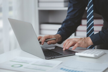 Businessman in a private office at his company and is reviewing company financial documents, senior management checking financial information for accuracy. Financial management.