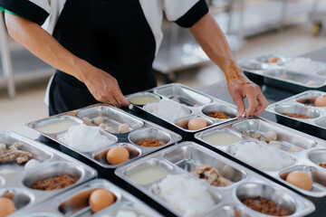 chef preparing food into a tray of food