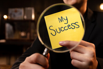 Businessman holding magnifying glass focusing on success, success is like a good leader, keyword...