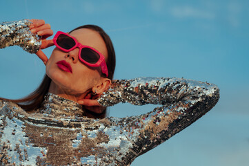 Fashionable confident woman wearing trendy fuchsia color rectangular sunglasses, sequin  turtleneck...