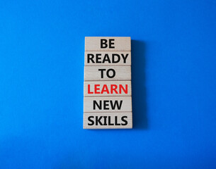 Learn new skills symbol. Concept words Be ready to Learn new skills on wooden blocks. Beautiful blue background. Business and Learn new skills concept. Copy space.