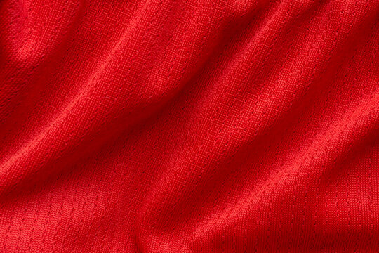 Red sports clothing fabric football shirt jersey texture background © Piman Khrutmuang