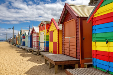 Obraz premium Brighton beach Victorian bathing boxes. Brightly painted colourful beach huts line the sand in Melbourne, Australia. They are highly desirable and extremely expensive real estate.