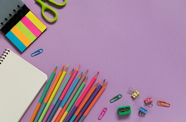 Fototapeta premium Bright modern school supplies on a purple background. Back to school concept. Top view. Copy space.