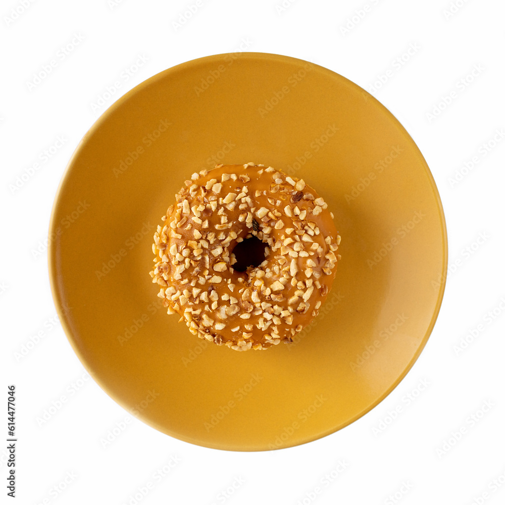 Poster Donut with caramel filling with nuts on a yellow plate on a white background. Isolate. Top view