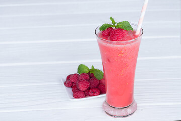 Raspberry smoothie red colorful fruit juice milkshake blend beverage healthy high protein the taste yummy In glass drink episode morning on a wooden background.